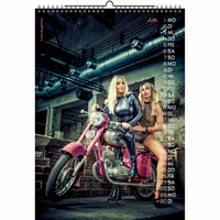 Two glamorous women in edgy outfits posing on a vintage pink motorcycle in an industrial setting, calendar page.