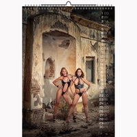 Calendar with two women in black lingerie standing in an old, ruined building.