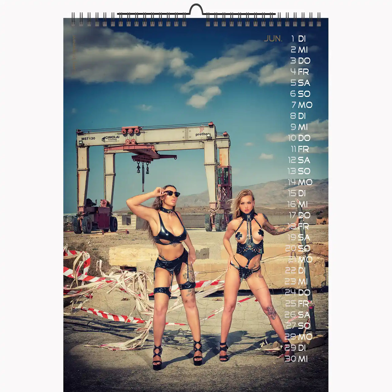 Calendar with two women in lingerie standing in front of a construction site.