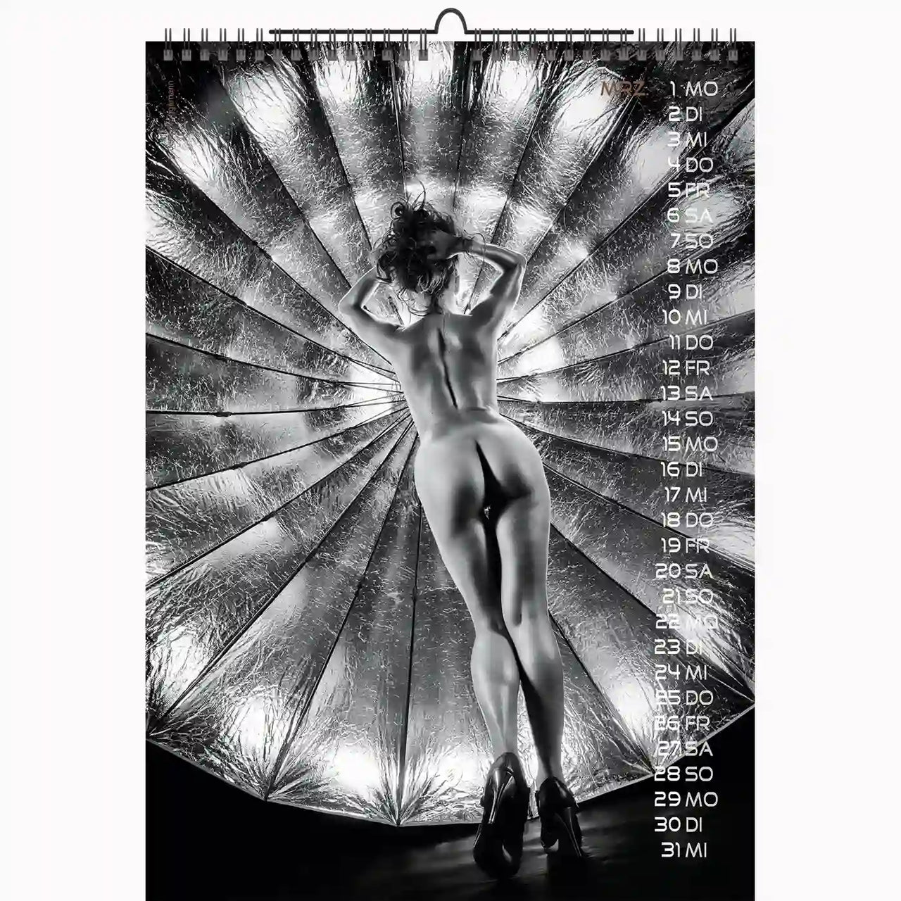 Calendar with a black and white photo of a person against a metallic spiral background