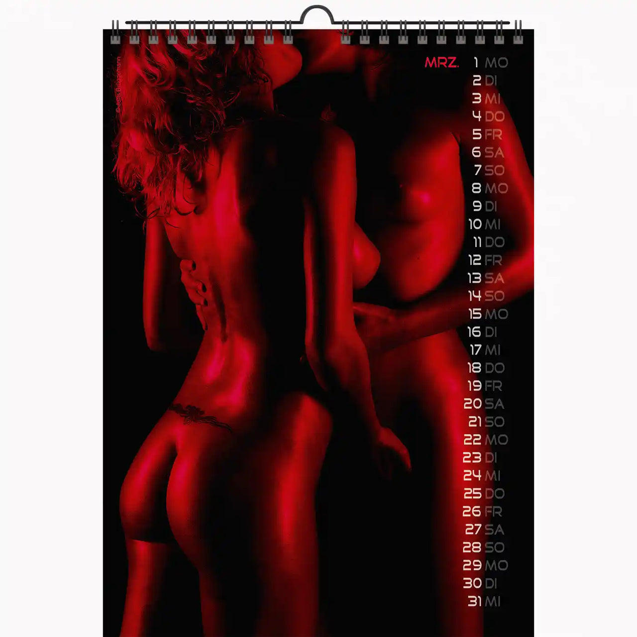 Calendar with a red and black design featuring a nude figure, displayed vertically.