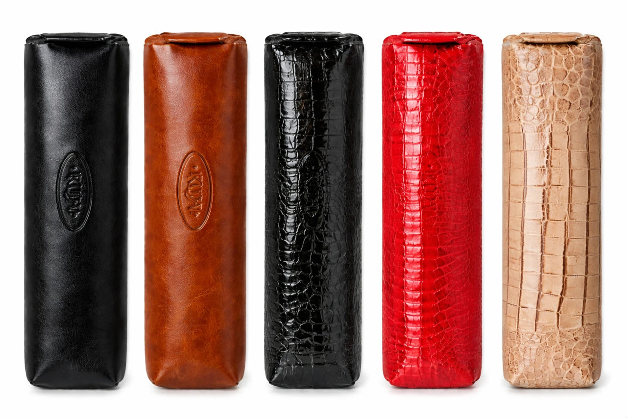 Vijf leren hoesjes in verschillende kleuren en texturen op een witte achtergrond