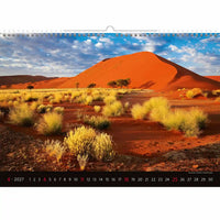 Kalender met een woestijnlandschap met rode zandduinen en schaarse vegetatie.