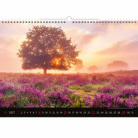 Kalender met een schilderachtig landschap van een boom en paarse bloemen bij zonsondergang.
