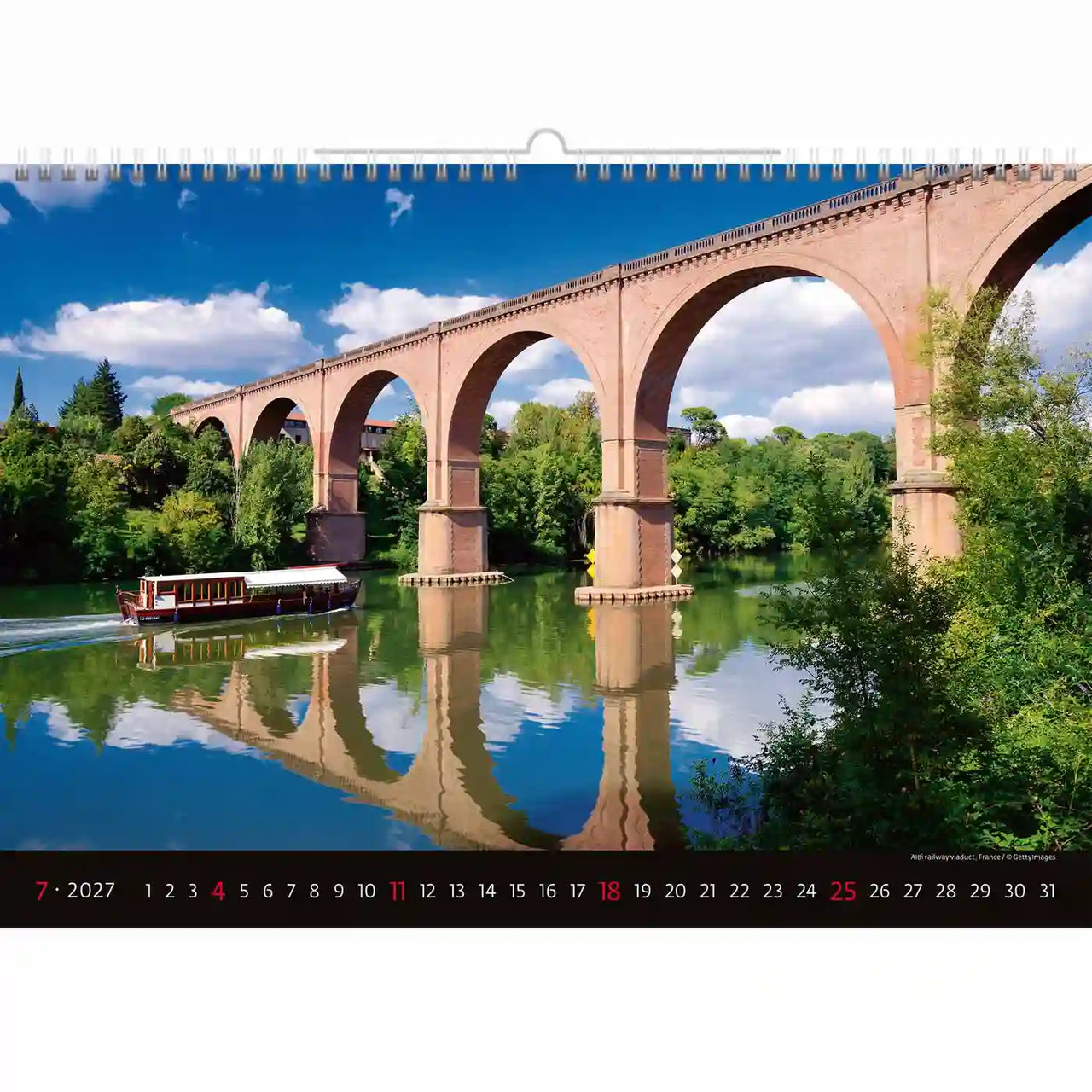 Kalender met een schilderachtig uitzicht op een brug over het water, met een boot en groen.