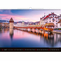 Kalender met een schilderachtig uitzicht op een stad aan een rivier in de schemering, met een brug en gebouwen.