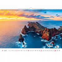 Kalender met een schilderachtig uitzicht op rotswanden en de oceaan bij zonsondergang.