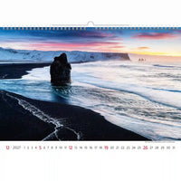 Kalender met een schilderachtig uitzicht op een zwart zandstrand en de oceaan bij zonsondergang.