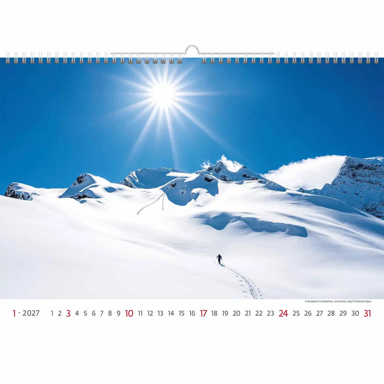 Kalender met een schilderachtig uitzicht op een besneeuwd berglandschap en een skiër.
