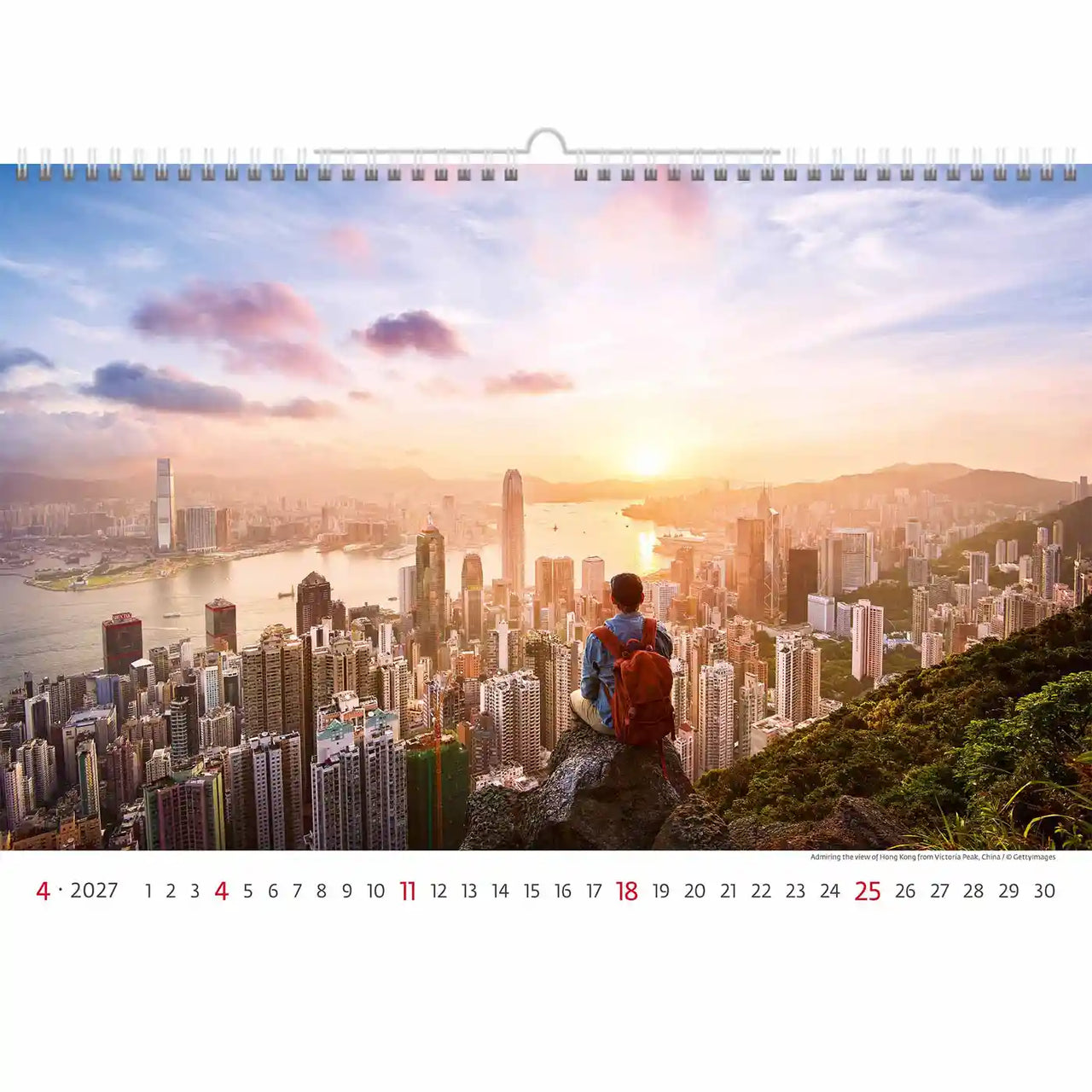 Kalender met een schilderachtig uitzicht op een stadsgezicht en een persoon met een rode rugzak, met een zonsondergang boven een groot stedelijk gebied.