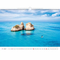 Kalender met een schilderachtig uitzicht op twee rotsachtige eilanden midden in een blauwe oceaan.