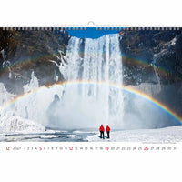 Kalender met een schilderachtig uitzicht op een waterval en regenboog, met twee mensen in rode jasjes.