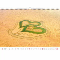 Kalender met een woestijntafereel met een grote letter 'B' en 'L' getekend in het zand.