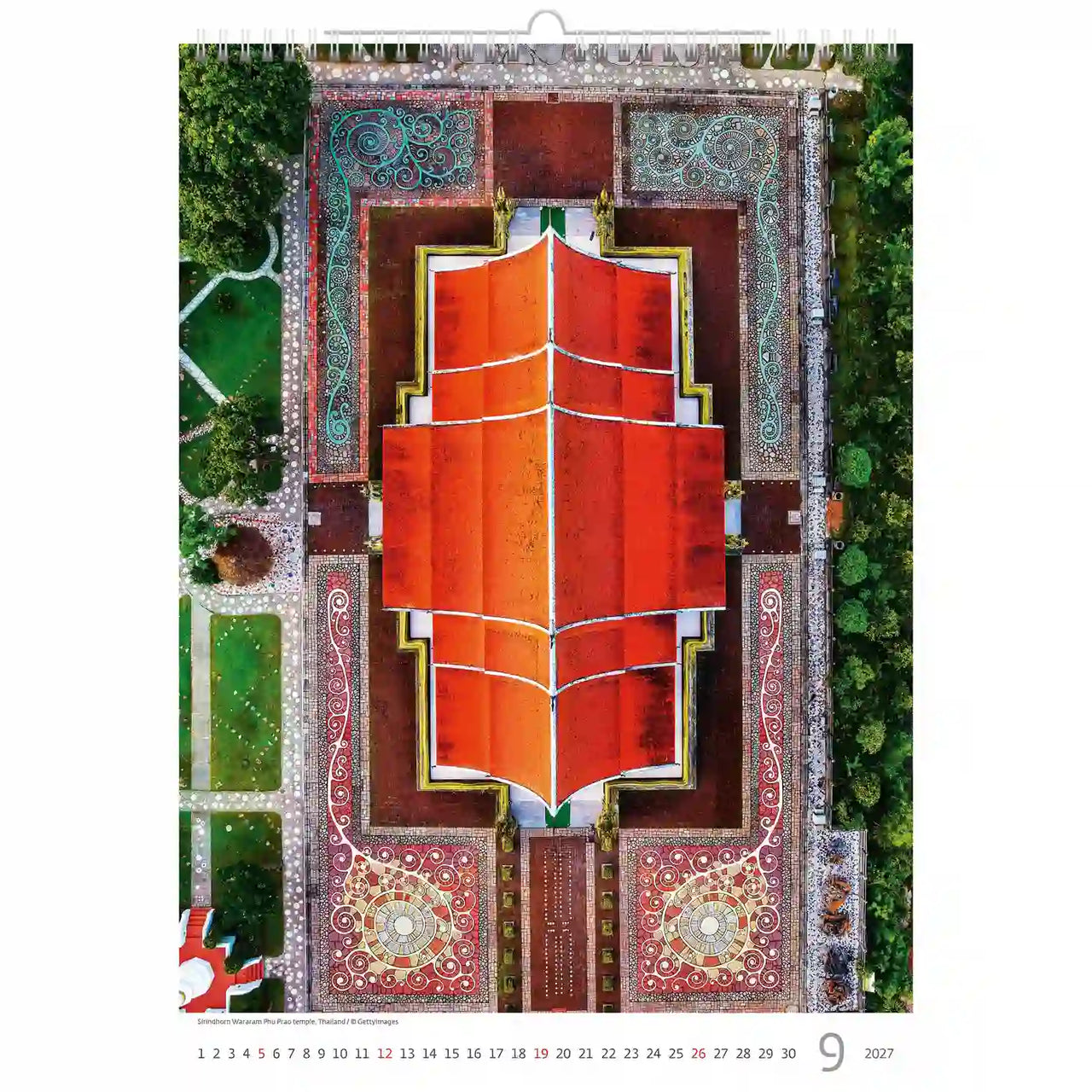 Luchtfoto van een gebouw met een rood dak, omgeven door groen, op een kalenderpagina.