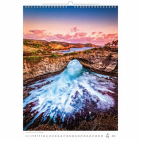 Kalender met panoramisch uitzicht op een klif en een natuurlijke brug over de zee bij zonsondergang.