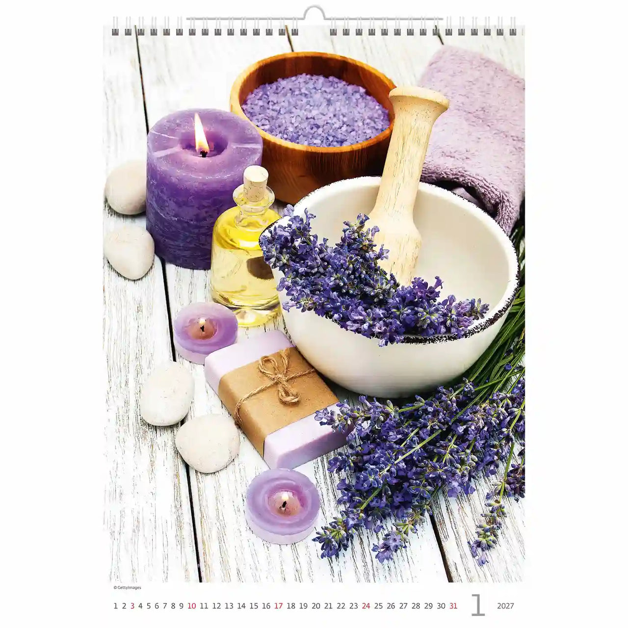 Jaarkalender met wellnessartikelen, waaronder een paarse kaars, een vijzel met lavendelbloemen en flesjes etherische oliën.
