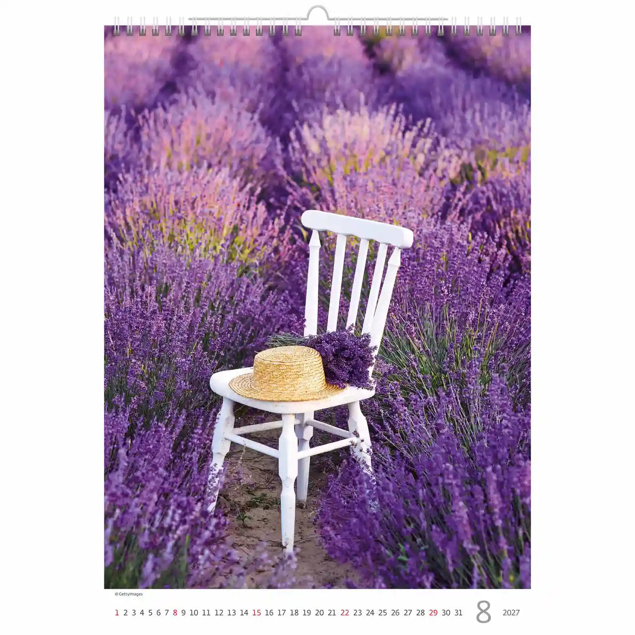 Kalenderpagina met een witte stoel in een lavendelveld, met daarop een strohoed en een bundel lavendel.