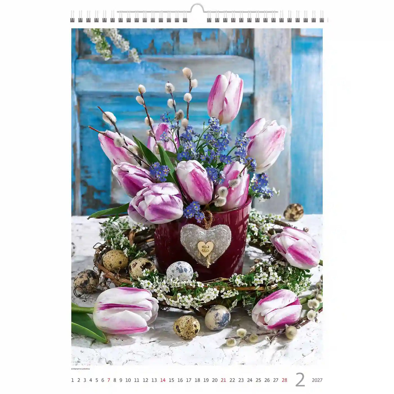 Bloemstuk met tulpen en decoratieve elementen op een kalenderpagina.