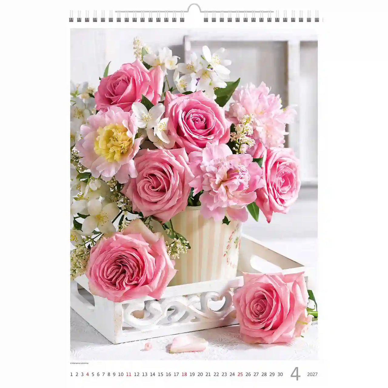 Bloemstuk met roze rozen en witte bloemen in een decoratieve setting