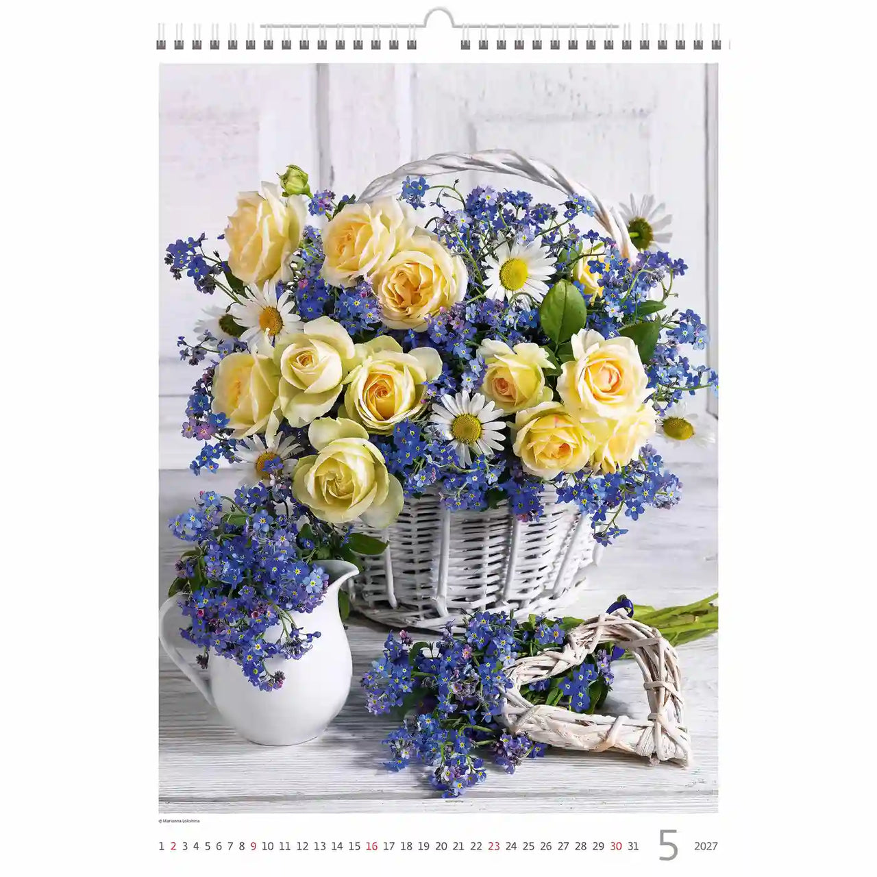 Bloemstuk met gele rozen en blauwe bloemen op een kalenderpagina.
