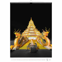 Decoratieve kalenderpagina met een grote, verlichte tempel en drakensculpturen op een zwarte achtergrond.