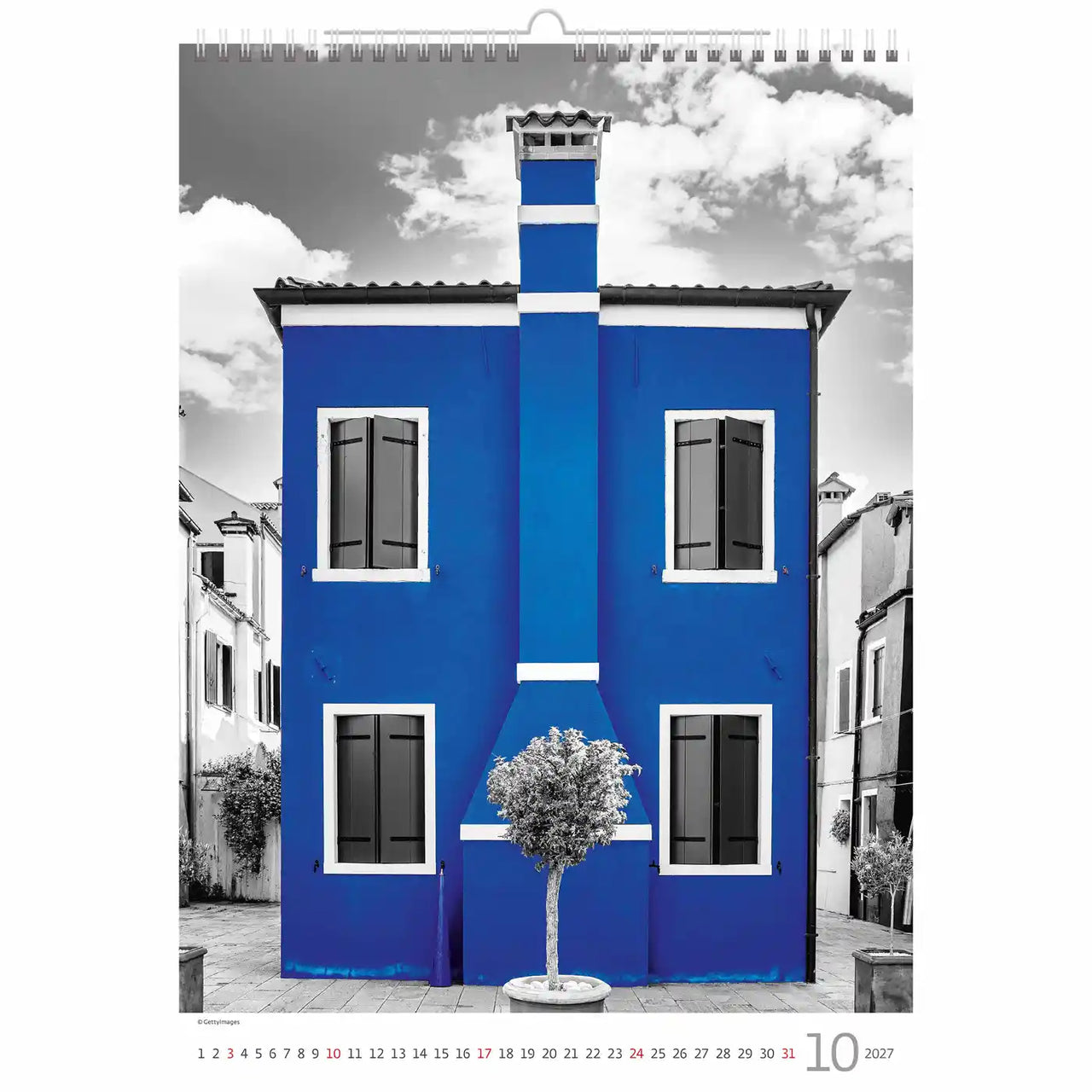 Kalenderpagina met een blauw gebouw en boom in een stadsomgeving