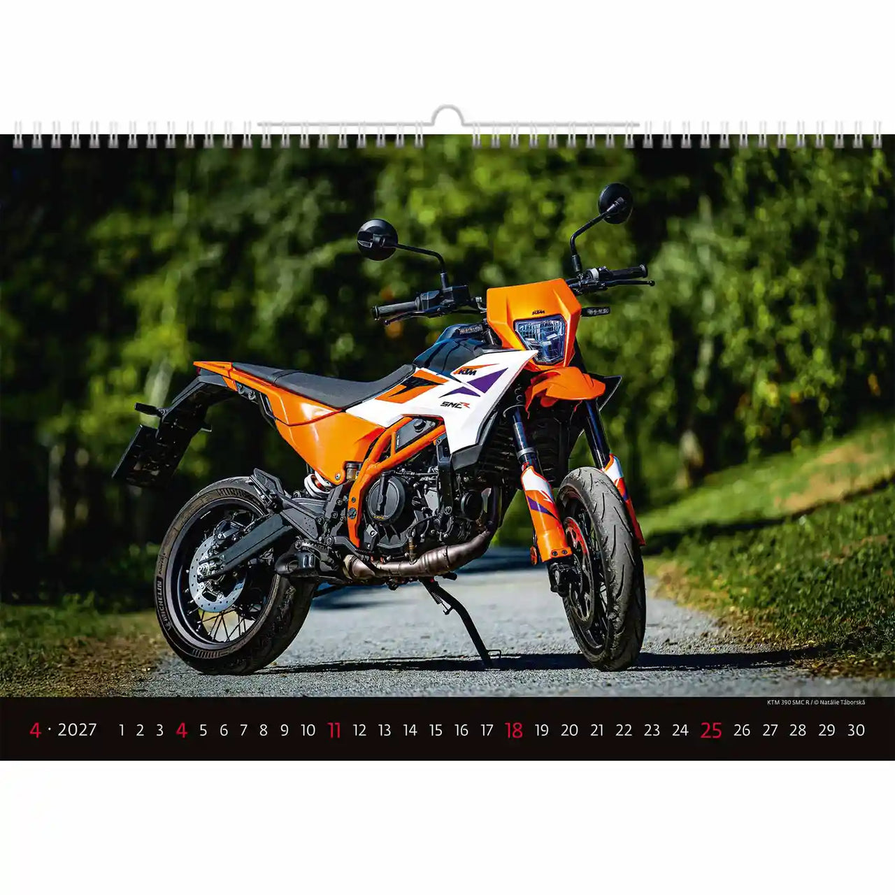Oranje motorfiets op een weg met onderaan een kalender