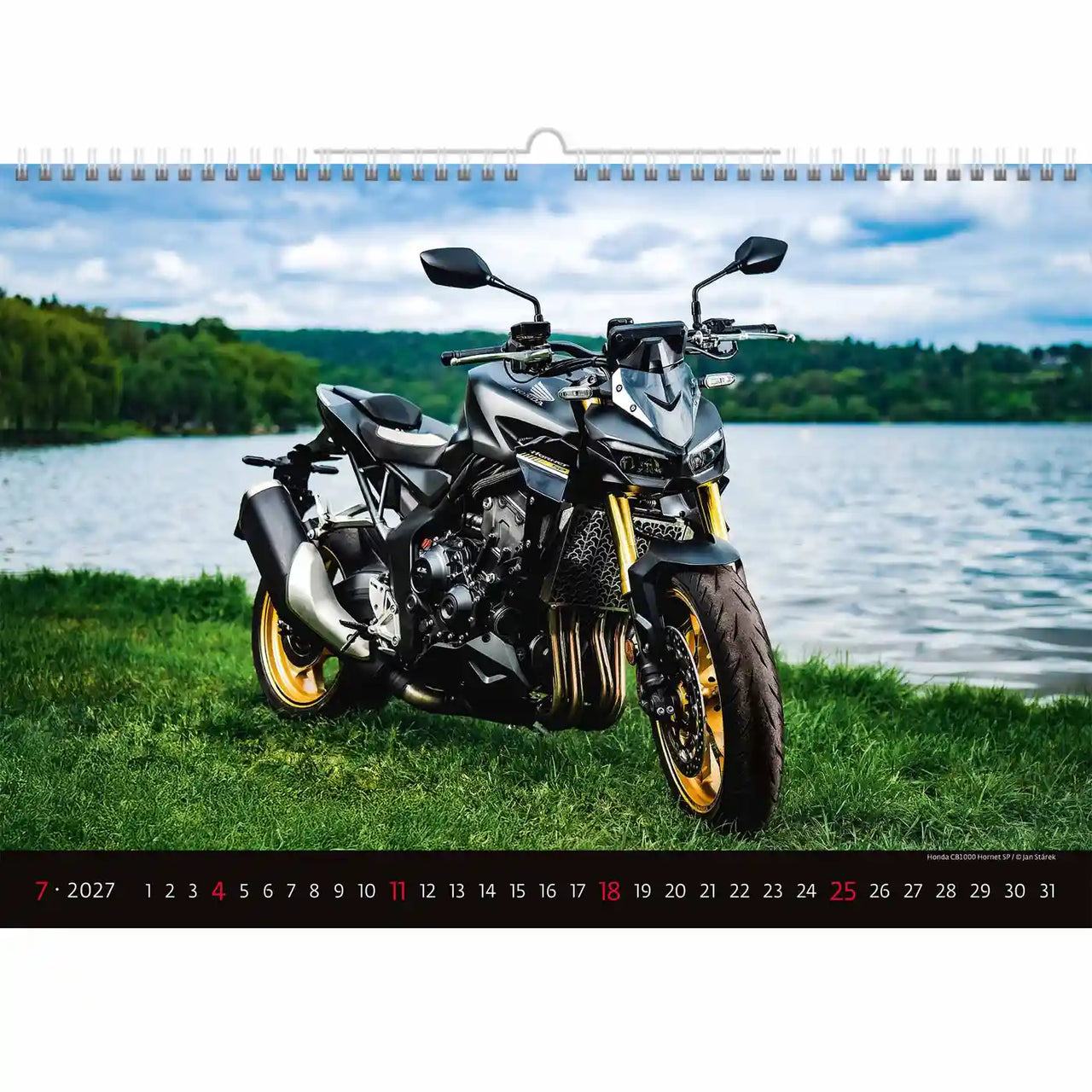 Motor op een grasveld met een schilderachtige achtergrond, met een kalender.