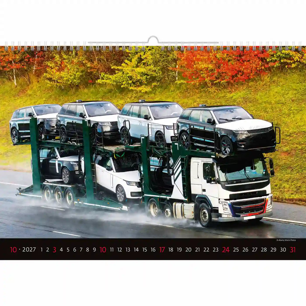 Kalender met een vrachtwagen die auto's vervoert op een weg met herfstbladeren op de achtergrond