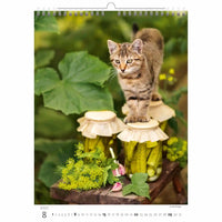 Kat op een decoratieve paddestoelstandaard met groen op de achtergrond