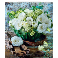 Arrangement floral avec des fleurs blanches et vertes dans un décor rustique, comportant le mot « janvier ».
