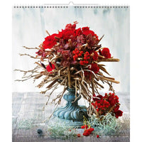 Arrangement décoratif avec fleurs et branches rouges sur une surface texturée