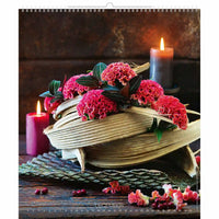 Nature morte décorative avec des fleurs roses, une bougie et des feuilles sur une surface texturée.
