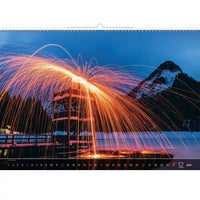Kalender met een schilderachtig uitzicht op een berg en lichtdisplay, met het getal 12 op een witte achtergrond.