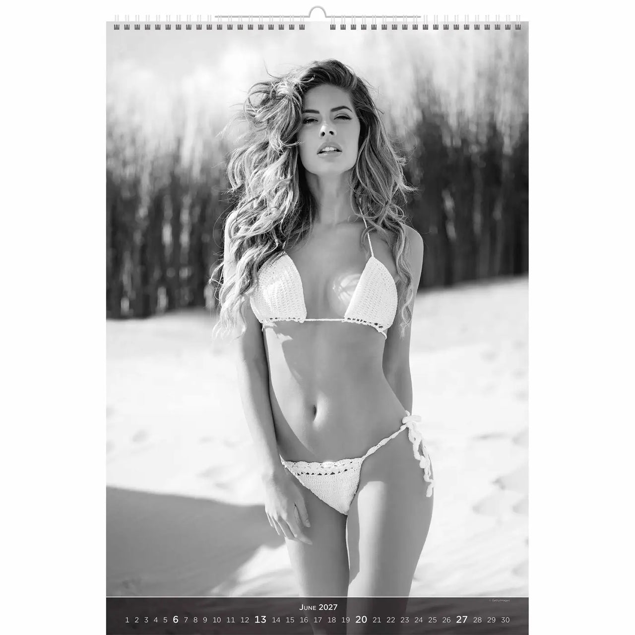 Kalenderpagina met een vrouw in een witte bikini die in een besneeuwd landschap staat.