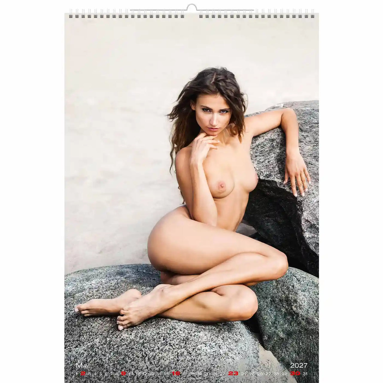 Naakte persoon zittend op een rots met een kalender in de hoek