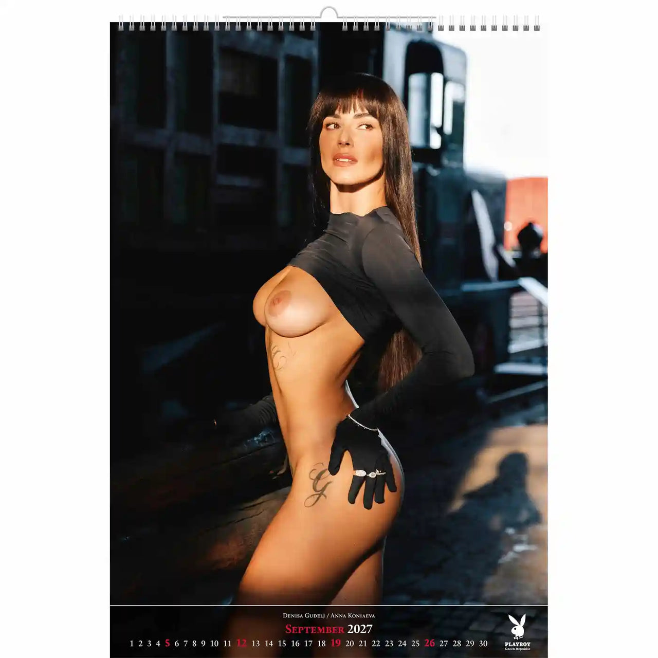 playboy kalender pagina met een model in een zwarte outfit en handschoenen.