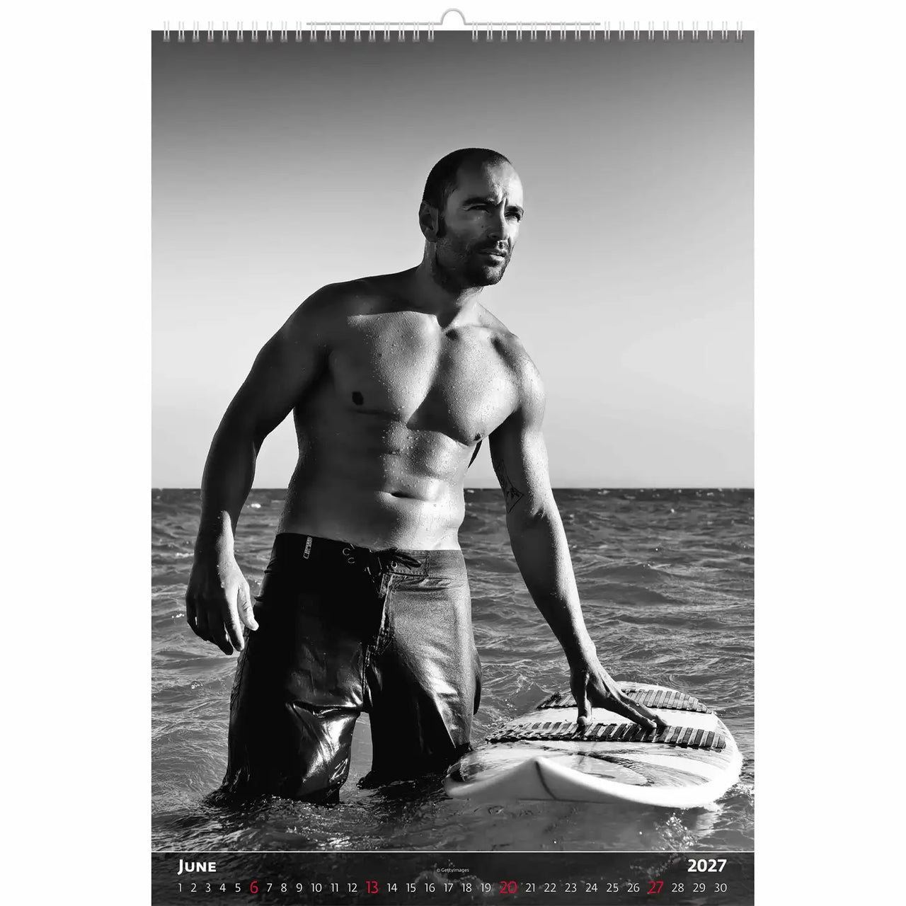 Zwart-wit kalenderpagina met een man met een surfplank in de oceaan.