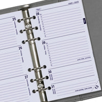 Close-up van een planner met een metalen ringband op een grijze achtergrond