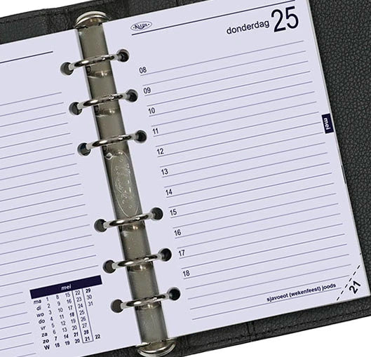 Close-up of a planner with a metal ring binding, showing a weekly layout.