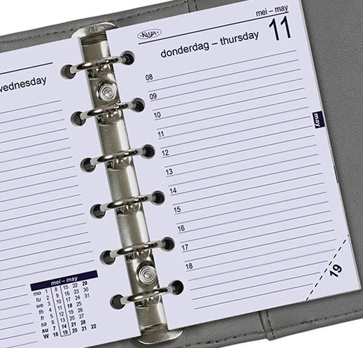 Close-up of a Kulesv planner with a metal ring binding on a gray background
