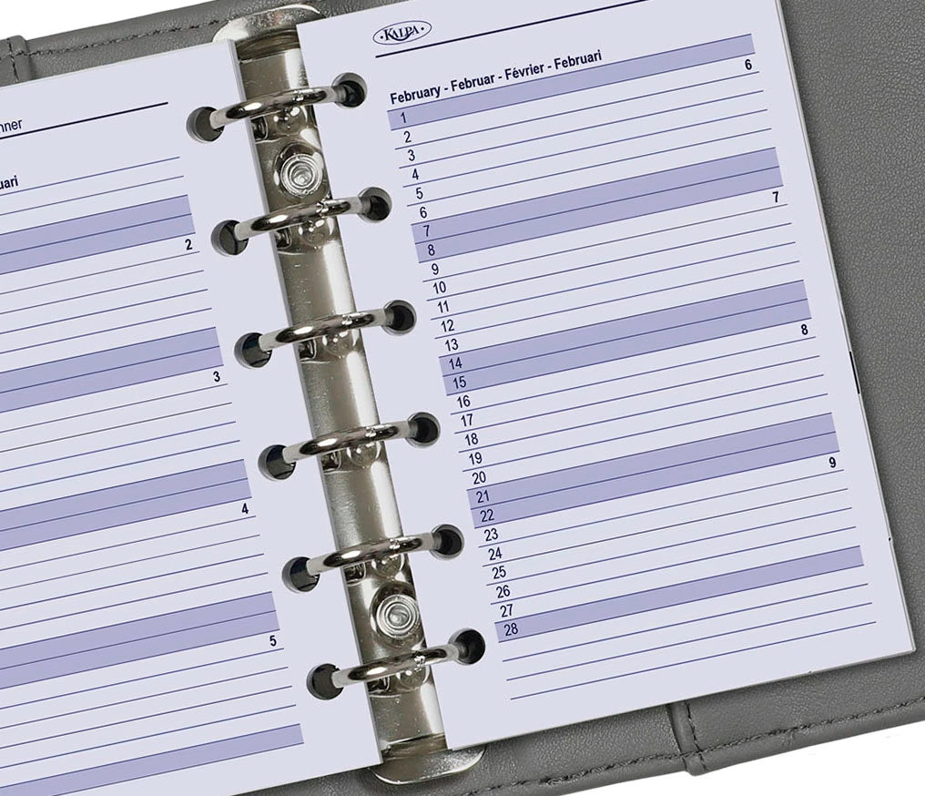 Close-up of a planner with a metal binding, showing a monthly layout.