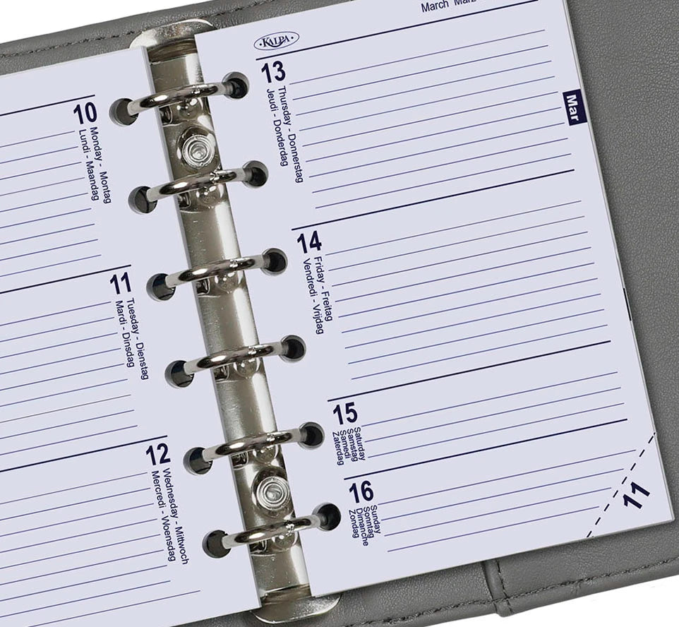Close-up of a planner with a metal binding, showing the pages and binding mechanism.