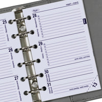 Close-up van een planner met een metalen ringbindsysteem op een grijze achtergrond