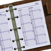 Close-up of a Kure planner with a monthly calendar on a wooden surface