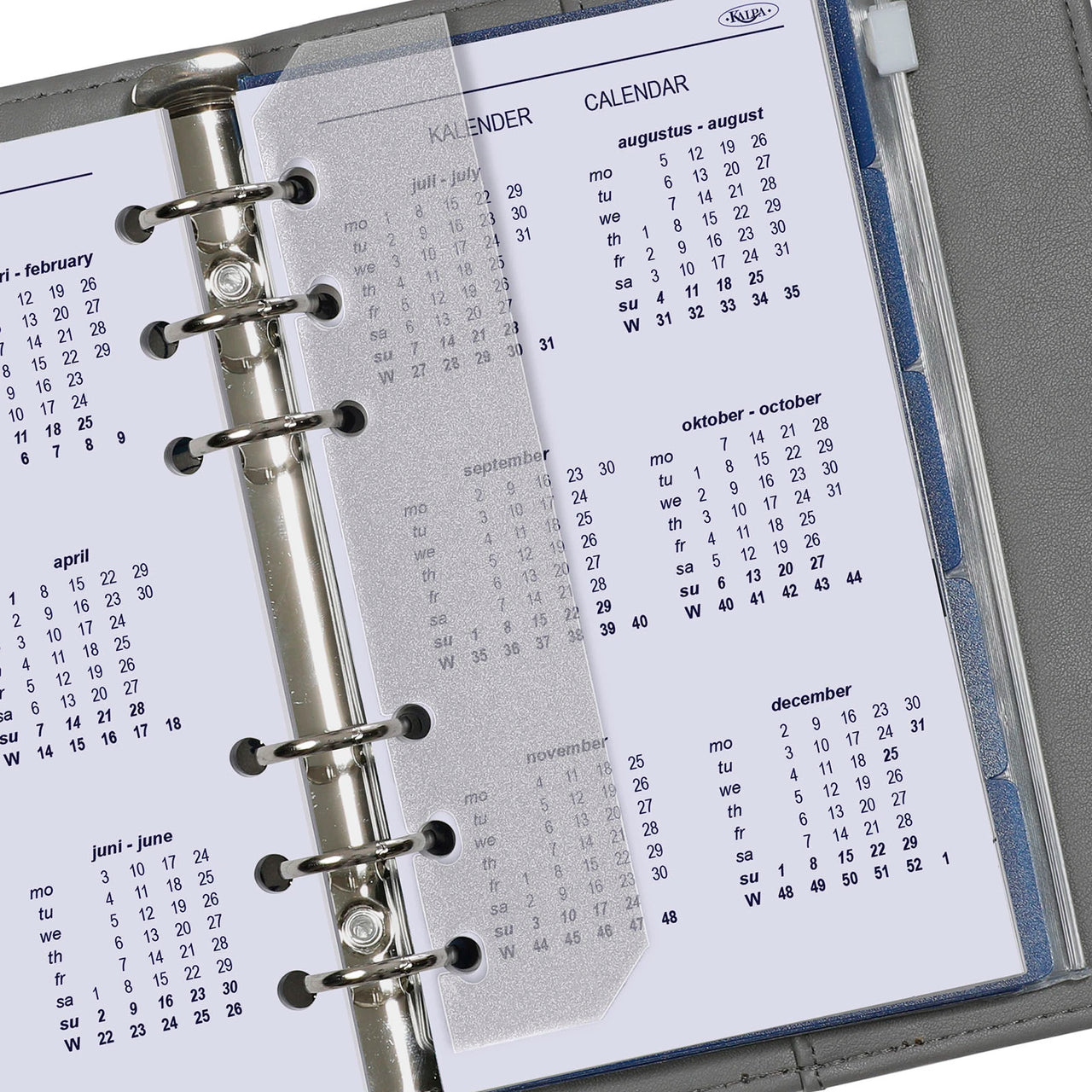 Kalender pagina's in een ringgebonden planner met zichtbare merknaam.