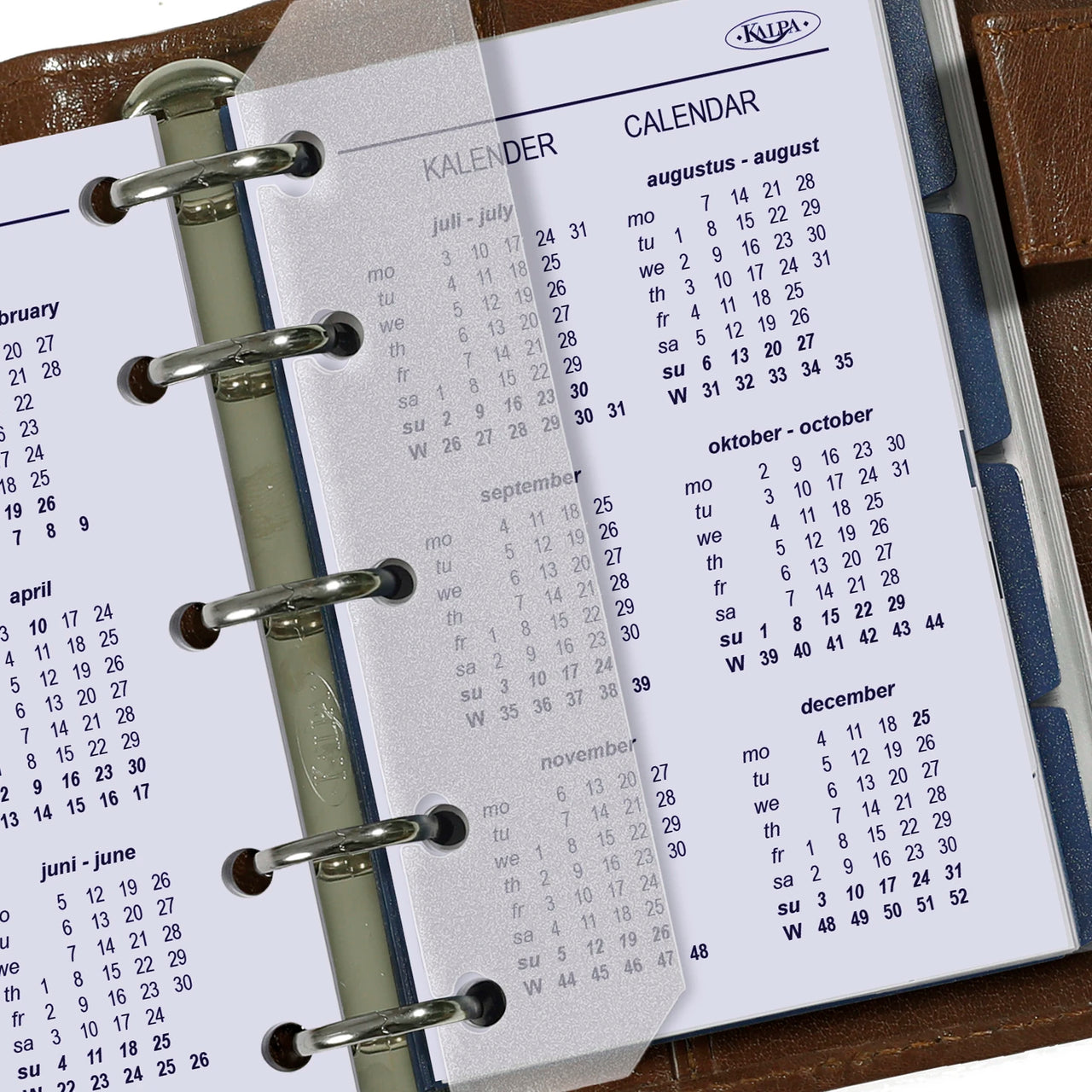 Calendar pages of a planner with metal rings on a wooden surface