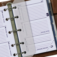 Close-up of a planner with a ring binding system on a wooden surface